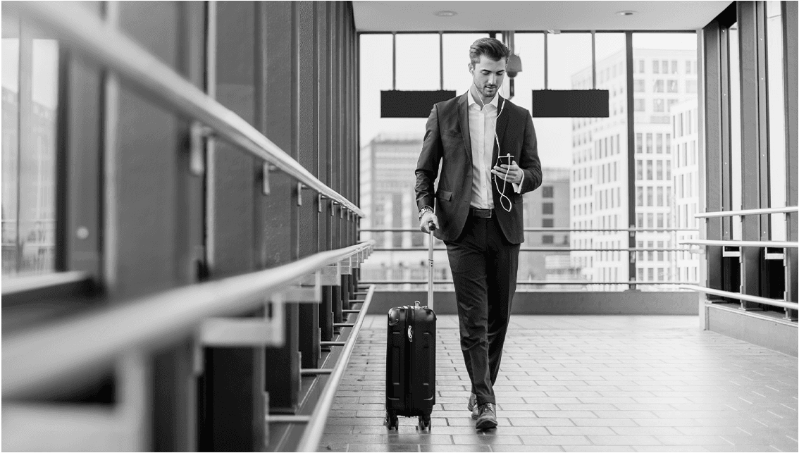 Grayscale traveler walking with suitcase